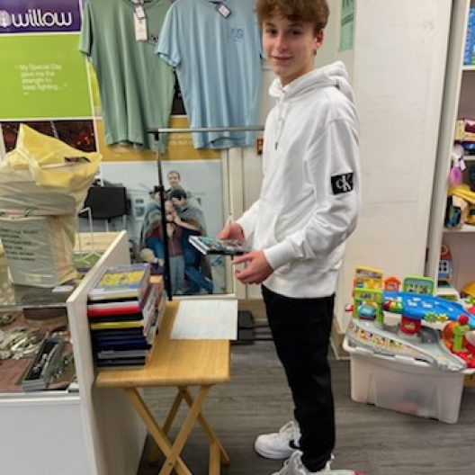 A picture of a young man standing in a shop sorting stock