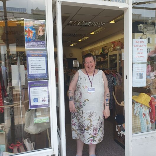 Becky stands smiling in the doorway to Willow's Hemel Hempstead shop