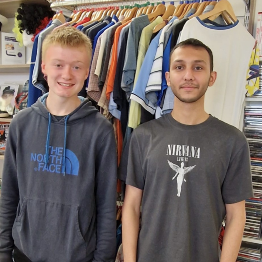 Two boys stand side by side in a shop