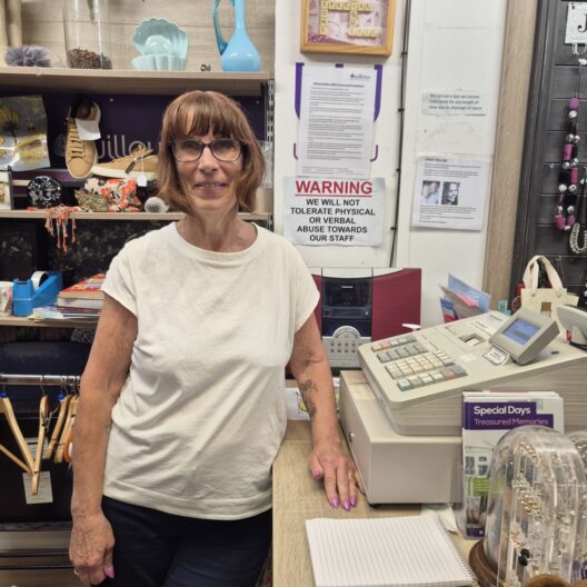 A lady stands beside a till