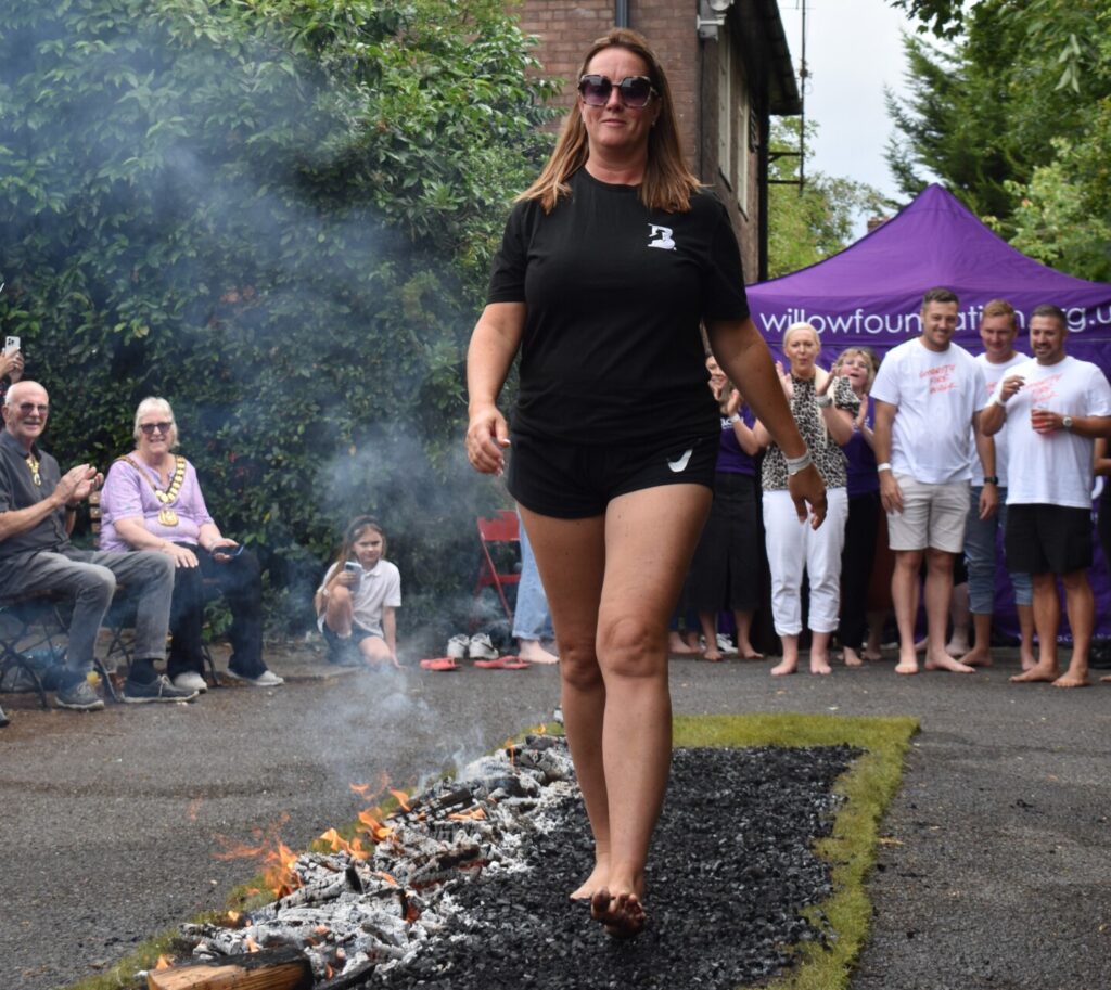 A woman from BlackPoint Recruitment walking on hot coals