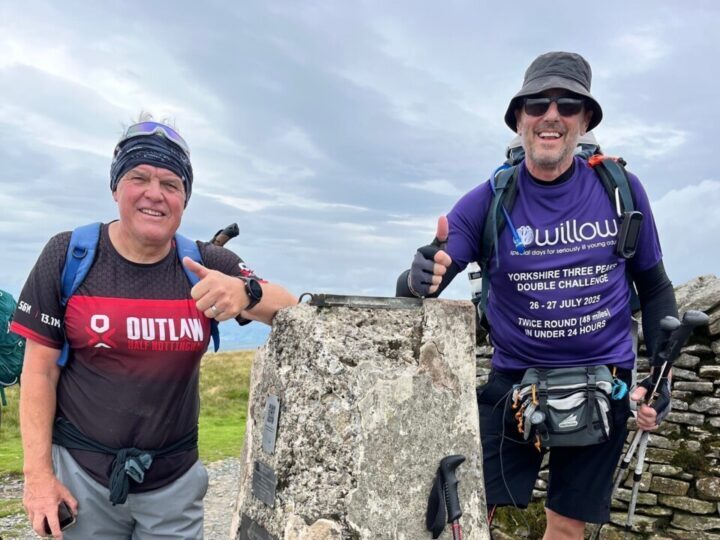 Rob and supporter smile with their thumbs up at the top of one of the peaks during his double three peaks challenge. 