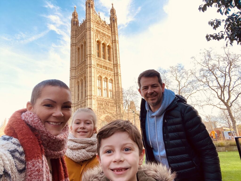 A woman who has lost her hair to breast cancer treatment enjoying a Willow Special Day in London with her partner and their two young children.