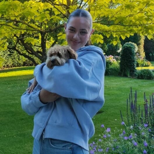 Woman holding a dog and smiling