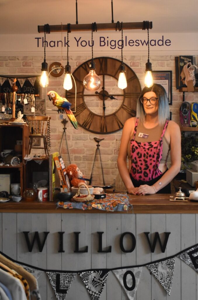 Volunteer Rose smiles as the Willow Biggleswade charity shop counter, in Bedfordshire. 