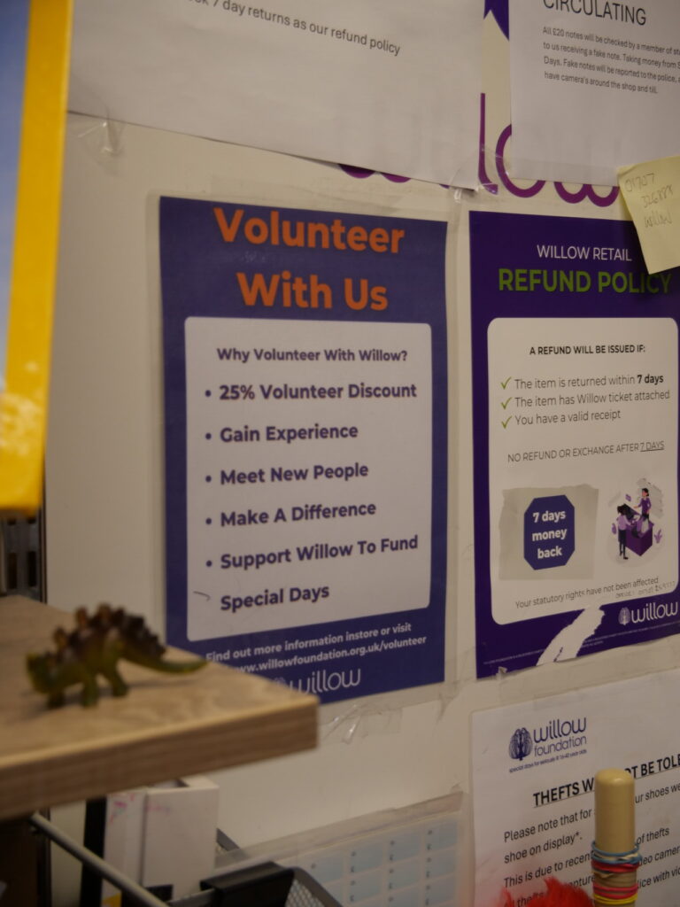 Sign inside Willow's Welwyn shop reads "Volunteer with us" 