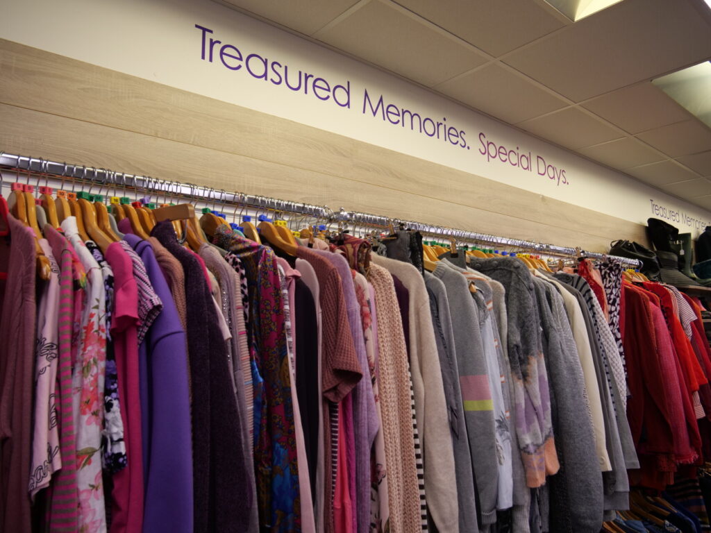 Rail of clothing in Hemel Hempstead shop, with wall stickers reading "Treasured Memories. Special Days"