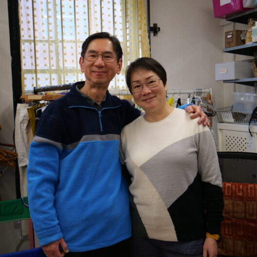Image of Annie and YS with their arms around each other's shoulders in the Welwyn shop.